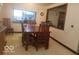 Bright dining room with a wooden table and seating for six, a window, and an open view to another room at 18378 Southeastern Pkwy, Fortville, IN 46040
