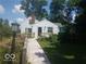 Quaint home exterior showcasing a wooden ramp, surrounding greenery, and lovely flower patches at 18378 Southeastern Pkwy, Fortville, IN 46040