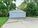 Two-car detached garage with a large concrete driveway surrounded by lush greenery at 18378 Southeastern Pkwy, Fortville, IN 46040