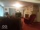 Cozy living room with a stone fireplace, comfortable seating, carpeted floors, and ample natural light at 18378 Southeastern Pkwy, Fortville, IN 46040