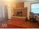 Living room showcasing a brick fireplace, hardwood floors, a window, and a classic chair at 18378 Southeastern Pkwy, Fortville, IN 46040