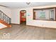 Inviting living room featuring wood-look floors and an opening view to the kitchen, with a staircase on the left at 18378 Southeastern Pkwy, Fortville, IN 46040