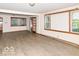 Open living room featuring light wood flooring, large windows, and neutral wall colors at 18378 Southeastern Pkwy, Fortville, IN 46040