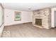 Spacious living room with a stone fireplace, wood-look floors, and a large window offering natural light at 18378 Southeastern Pkwy, Fortville, IN 46040