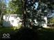 Exterior view of outbuilding with a white metal finish, set amongst a green, tree-filled backyard at 18378 Southeastern Pkwy, Fortville, IN 46040