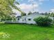 Rear exterior view with well-maintained lawn, deck and mature trees, offering privacy and outdoor enjoyment at 18378 Southeastern Pkwy, Fortville, IN 46040