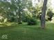 Lush, grassy yard with mature trees providing ample shade and natural beauty at 18378 Southeastern Pkwy, Fortville, IN 46040