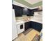 A well-lit kitchen is equipped with sleek, dark cabinetry, modern appliances, and an attractive backsplash at 205 Eikenberry St, Greenfield, IN 46140