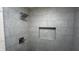 Close-up of tiled shower with a built-in niche and rainfall shower head at 2083 Kerns Ct, Carmel, IN 46280