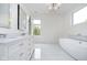 Elegant bathroom with double sinks, standalone tub, and large window for natural light at 2130 Brookside Pkwy N Dr, Indianapolis, IN 46201