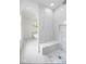 Elegant bathroom with marble-look tiling, frameless shower and soaker tub at 2130 Brookside Pkwy N Dr, Indianapolis, IN 46201