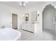Bright bathroom featuring marble floors, double sinks, a soaking tub, and stylish fixtures at 2130 Brookside Pkwy N Dr, Indianapolis, IN 46201