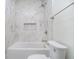 Bright bathroom features marble wall tiles, a shower and tub combination, and a modern design at 2130 Brookside Pkwy N Dr, Indianapolis, IN 46201