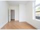 Bright bedroom with hardwood floors, fresh white walls, and natural light from a nearby window at 2130 Brookside Pkwy N Dr, Indianapolis, IN 46201