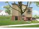 Modern home with a large tree in the yard, featuring balconies and tan siding at 2130 Brookside Pkwy N Dr, Indianapolis, IN 46201
