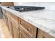 A kitchen features marble countertops and rich brown cabinets with sleek, modern hardware at 2130 Brookside Pkwy N Dr, Indianapolis, IN 46201