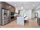 A bright, open kitchen with a stainless steel fridge and marble island with modern seating at 2130 Brookside Pkwy N Dr, Indianapolis, IN 46201