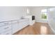 Laundry room with white cabinets, hardwood flooring, and a pet washing station at 2130 Brookside Pkwy N Dr, Indianapolis, IN 46201