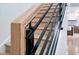 Close-up of modern staircase with wooden handrail and black iron spindles and wood stairs at 2130 Brookside Pkwy N Dr, Indianapolis, IN 46201