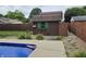 Backyard view with an outbuilding, an in-ground pool, and a stone patio surrounded by a wooden privacy fence at 2239 Chevelle Ct, Anderson, IN 46012