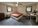 This bedroom features a platform bed, two windows, ceiling fan, and workspace; perfect for a relaxing retreat at 2239 Chevelle Ct, Anderson, IN 46012
