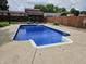 Backyard featuring an in-ground pool with a concrete surround and an outbuilding with green shutters in background at 2239 Chevelle Ct, Anderson, IN 46012