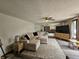 Bright living room featuring a large sectional couch, neutral decor, and a ceiling fan for comfortable living at 2239 Chevelle Ct, Anderson, IN 46012