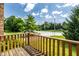 View from a wooden balcony showing lush greenery and neighborhood street at 2411 N Willow Way, Indianapolis, IN 46268