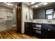 Modern bathroom with a double sink vanity, glass shower, and wood-look flooring at 2411 N Willow Way, Indianapolis, IN 46268