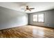 Spacious bedroom featuring hardwood floors, a ceiling fan, and a window offering ample natural light at 2411 N Willow Way, Indianapolis, IN 46268