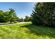 Landscaped entrance to the neighborhood featuring lush greenery and a clear blue sky at 2411 N Willow Way, Indianapolis, IN 46268