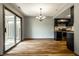 Dining area with sliding glass doors and modern chandelier adjacent to the black kitchen at 2411 N Willow Way, Indianapolis, IN 46268