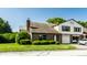 Exterior of a well-kept townhouse with a brick facade, attached garage, and manicured landscaping at 2411 N Willow Way, Indianapolis, IN 46268