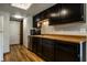Galley kitchen featuring black cabinets, wood countertops, and stainless steel appliances at 2411 N Willow Way, Indianapolis, IN 46268
