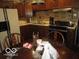 Traditional kitchen with dark cabinets, stainless steel appliances, and breakfast table at 2610 Marywood Dr, Southport, IN 46227