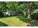 Spacious backyard with mature trees and a weathered fence for privacy at 2702 S Moreland Ave, Indianapolis, IN 46241