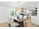 Dining area with a modern chandelier, wood table, and a view into the updated kitchen at 2715 S A St, Elwood, IN 46036