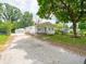 View of single-story home, detached garage, long gravel driveway, and fenced front yard at 2909 S Randolph St, Indianapolis, IN 46203