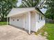 A detached two-car garage has a concrete driveway, door to yard and mature trees at 2909 S Randolph St, Indianapolis, IN 46203