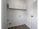 Bright laundry room with overhead cabinets and access door at 2909 S Randolph St, Indianapolis, IN 46203