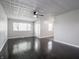 Bright living room featuring dark hardwood floors, ceiling fan, and fresh gray paint at 2909 S Randolph St, Indianapolis, IN 46203