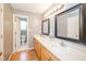Bathroom with double vanity, framed mirrors, light fixtures, and wood floors at 296 Myers Lake Dr, Noblesville, IN 46062