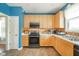 Well-lit kitchen with stainless steel appliances, wooden cabinets, and tile flooring, offering ample storage and workspace at 296 Myers Lake Dr, Noblesville, IN 46062