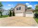 Side view of a home showcasing a three-car garage, driveway, and basketball hoop at 3058 Mcintosh Dr, Bargersville, IN 46106