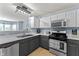 Well-lit kitchen features stainless steel appliances, gray cabinets, and white upper cabinets at 3058 Mcintosh Dr, Bargersville, IN 46106