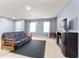 Spacious living room featuring neutral walls, TV, windows with curtains, and a comfortable futon sofa at 3058 Mcintosh Dr, Bargersville, IN 46106