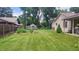 Large backyard with lush green grass, garden area, and mature trees offering shade and privacy at 3422 Sycamore Dr, Columbus, IN 47203