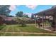 Spacious backyard featuring a well-manicured lawn, privacy fence, mature trees, and a covered patio at 3422 Sycamore Dr, Columbus, IN 47203