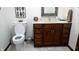 Bathroom featuring a toilet, vanity with granite countertop, and wooden cabinets at 3422 Sycamore Dr, Columbus, IN 47203