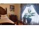 Bright bedroom featuring a queen-sized bed and large window with hanging decorations for a cozy feel at 3422 Sycamore Dr, Columbus, IN 47203